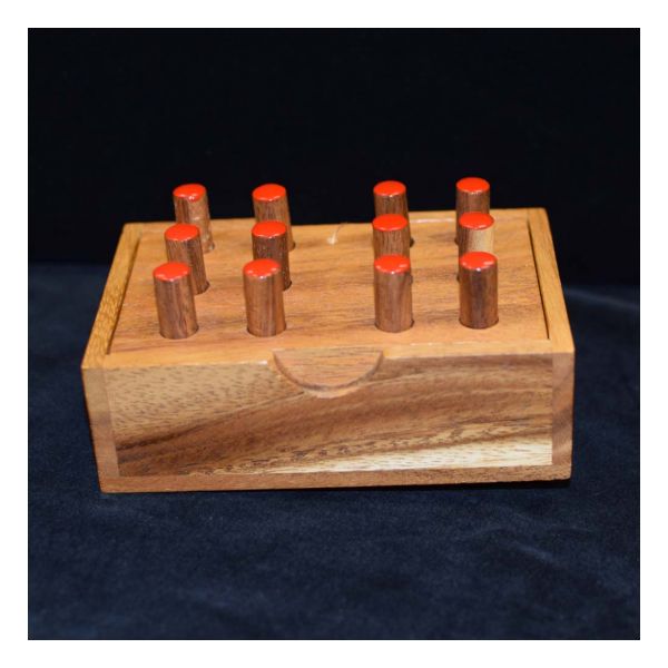 Wood base with two Braille cells containing red wood pegs.